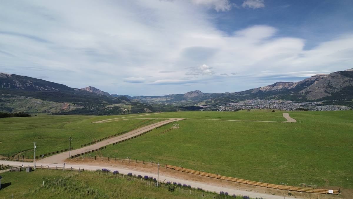 Pradera abierta del predio con el camino de acceso